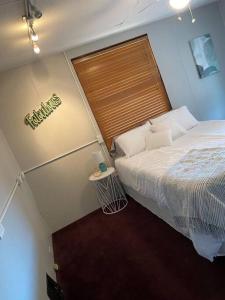 Dormitorio pequeño con cama y cartel en la pared en 2-Bedroom Quincy Apt. with private parking & Wifi, en Quincy