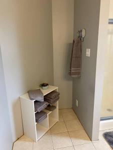a bathroom with a white shelf with towels on it at 2-Bedroom Quincy Apt. with private parking & Wifi in Quincy