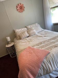 a bedroom with a bed with a pink blanket on it at 2-Bedroom Quincy Apt. with private parking & Wifi in Quincy