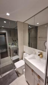 a bathroom with a toilet and a sink and a shower at Apartamento completo na praia brava in Itajaí +17 photos
