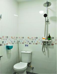 a white bathroom with a toilet and a shower at Octopus House Langkawi Easy Shop Easy Play in Kuah