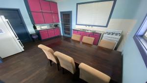 a kitchen with a table and chairs and red cabinets at Blue Beach House in Jurien Bay +4 photos