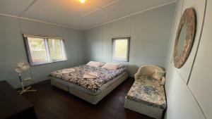 a bedroom with a bed and a chair in it at Blue Beach House in Jurien Bay