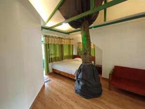 a bedroom with a bed and a tree in a bag at SpiceBuds FarmStay - Ramakkalmedu in Idukki