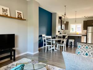 a living room and kitchen with a table and chairs at Entire Home Near Calgary, Canmore & Banff Rocky Mountain Gateway in Cochrane