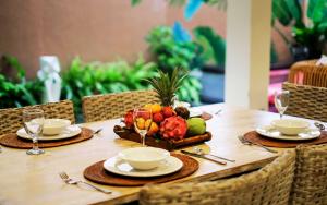 una mesa de madera con platos y cuencos de fruta. en Aroha Boutique Villas en Seminyak