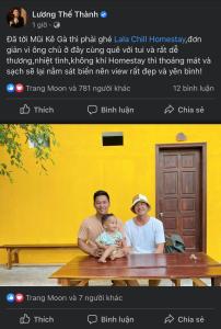 a man and a woman holding a baby sitting on a bench at Lala Chill Homestay in Ke Ga