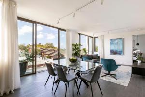 a living room with a glass table and chairs at Botanik Apartment Hotel in Sydney