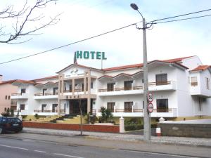 un hôtel situé sur le côté d'une rue dans l'établissement Hotel Ouro Verde, à Praia da Vieira
