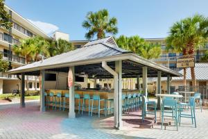 un kiosque avec des chaises et des tables ainsi qu'un bar dans l'établissement Staybridge Suites Orlando Royale Parc Suites, an IHG Hotel, à Orlando