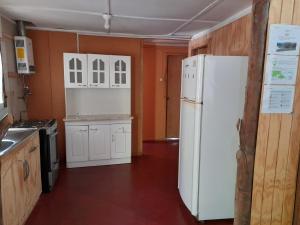 a kitchen with white appliances and a white refrigerator at Refugio de montaña in Melipeuco
