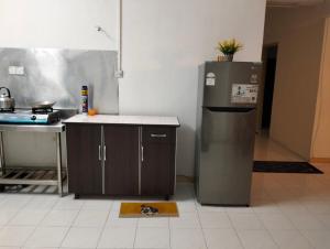 a kitchen with a counter and a refrigerator in a room at Pantai Puteri Kondominium in Kampong Bukit Darat