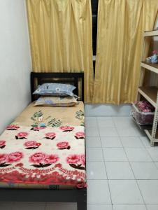- une chambre avec un lit orné de fleurs roses dans l'établissement Pantai Puteri Kondominium, à Kampong Bukit Darat