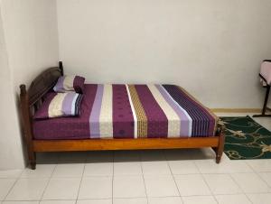 - un lit avec une couverture rayée dans l'établissement Pantai Puteri Kondominium, à Kampong Bukit Darat