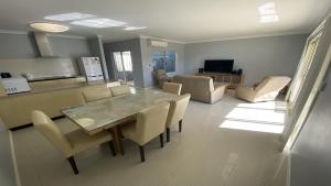 Unit 36 Seafront Estate في جوريين باي: غرفة طعام وغرفة معيشة مع طاولة وكراسي