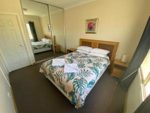 a bedroom with a bed and a large mirror at Unit 27 Seafront Estate in Jurien Bay +9 photos