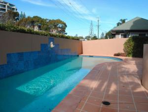 a swimming pool in a backyard with a fence at Millenium 101 in Forster