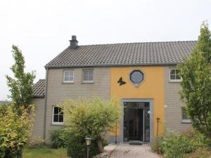 a yellow and gray house with a door at Luxury holiday home in Marchin with wellness in Marchin