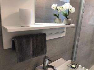 baño con lavabo, espejo y toalla en studio m - Stylish Central City Business Apartment for 5 guests, en Düsseldorf