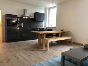 a kitchen with a wooden table and a dining room at studio m - Stylish Central City Business Apartment for 5 guests in Düsseldorf