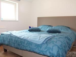 een bed met blauwe lakens en kussens erop bij Luxury holiday home in Marchin with wellness in Marchin