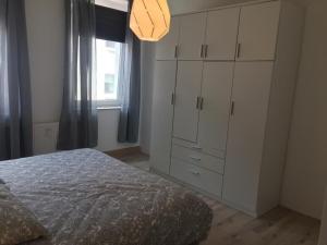 1 dormitorio con 1 cama, vestidor y ventana en studio m - Stylish Central City Business Apartment for 5 guests, en Düsseldorf