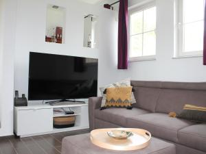 een woonkamer met een bank en een flatscreen-tv bij Luxury holiday home in Marchin with wellness in Marchin