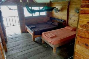 Habitación con 2 camas y hamaca. en Private Cabin Over the Water PLUS Meals - San Blas Islands - private bathroom, en Panamá