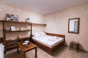 Dormitorio pequeño con cama y mesa en OVGORA - Ismini Sea View Room in Kamilari Village, en Kamilari