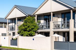 a white fence in front of a house at Nautilus Lodge Motel in Motueka +19 photos