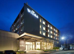 a building with a sign on the side of it at HOTEL WISMA RATCHABURI in Ratchaburi