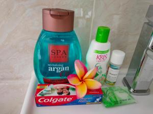a bathroom counter with a bottle of soap and a flower at Nadi Fancy Hotel in Nadi