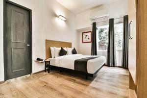 a hotel room with a bed and a window at Townhouse 182 Menka in Patna