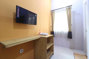 einen Flachbild-TV an einer Wand in einem Zimmer in der Unterkunft Bedur Homestay Syariah in Bekasi
