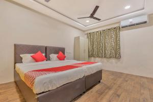 um quarto com uma cama grande e almofadas vermelhas em Hotel Ruby Grand Opp Apollo Hospital Kondapur em Kondapur