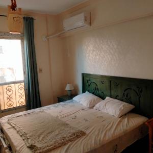 a bedroom with a large bed with a window at Afnan Guest- Rehab City in Burg el-Ḥudûd
