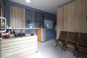 uma cozinha com 2 cadeiras e um frigorífico em Bedur Homestay Syariah em Bekasi