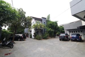 a parking lot with cars parked in front of a house at Bedur Homestay Syariah in Bekasi