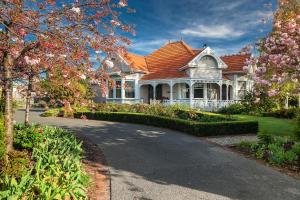 a white house with a red roof and a driveway at Anglesea House Inn in Renwick