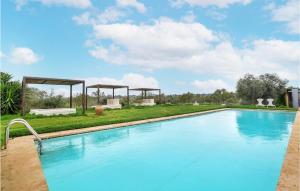 a large swimming pool in a yard with chairs and tables at Beautiful Home In Caltagirone in Caltagirone +24 photos