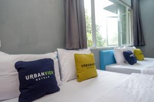 een kamer met een bed met kussens erop bij Urbanview Hotel Umbrella Dieng by RedDoorz in Kalibeber