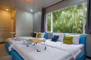 two beds in a room with a large window at Urbanview Hotel Umbrella Dieng by RedDoorz in Kalibeber