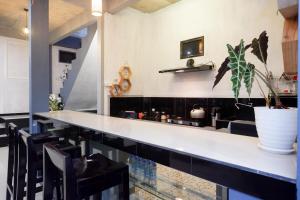 a kitchen with a white counter and a potted plant at Urbanview Hotel Umbrella Dieng by RedDoorz in Kalibeber