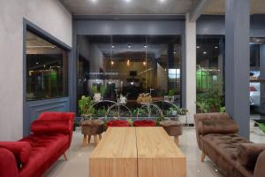 una sala de estar con sofás y una mesa de centro en una habitación en Urbanview Hotel Umbrella Dieng by RedDoorz, en Kalibeber