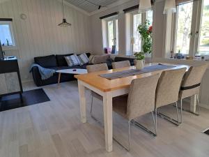 a kitchen and living room with a table and chairs at Cottage Langan in Strömstad