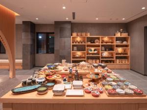 MIMARU SUITES Tokyo NIHOMBASHI في طوكيو: طاولة عليها العديد من الأطباق والأطباق