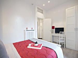 ローマにあるVelvet Trastevere Apartmentの白いベッドルーム(赤いベッド1台、デスク付)