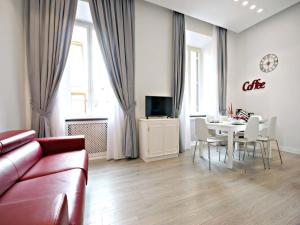 ローマにあるVelvet Trastevere Apartmentのリビングルーム(ソファ、テーブル、椅子付)