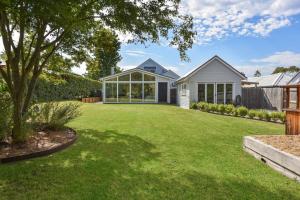 a large yard with a house with a large window at Alleura House in Leura