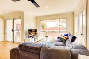 a living room with a couch and a tv at Boutique by Jervis Bay by Experience Jervis Bay in Vincentia